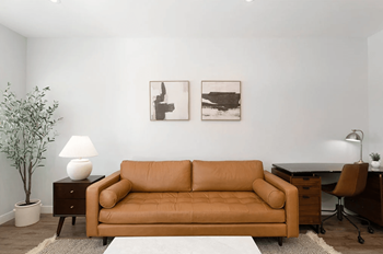 A living room with a couch and two paintings on the wall